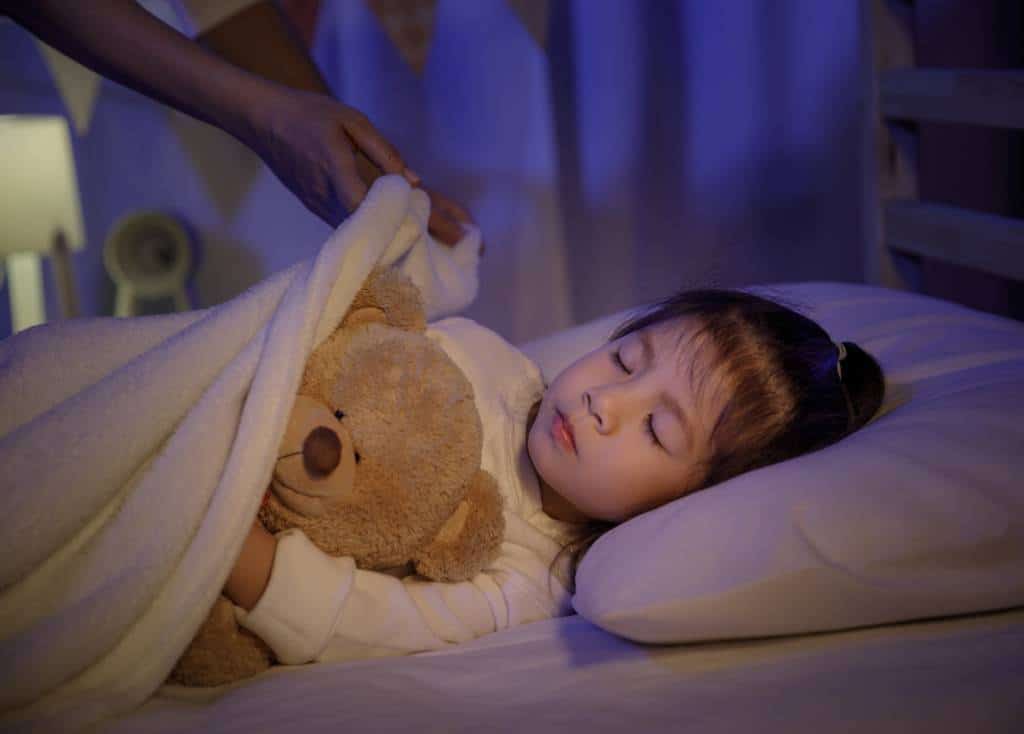 Enfant qui dort grâce à un plafond étoilé rassurant